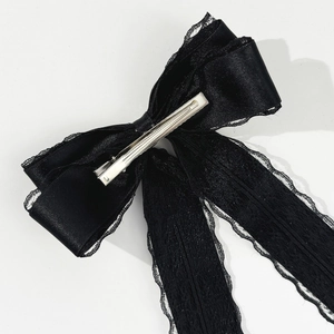 Detail view of the metal duckbill clip on the back of the black lace bow hair clip