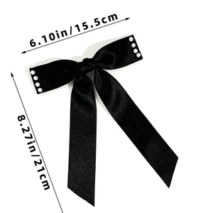 Détail du nœud de cheveux en satin noir avec perles et dimensions de 15,5x21cm environ