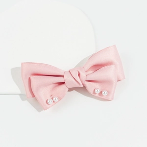 Détail de la pince à cheveux à nœud en satin rose avec perles et design double couche