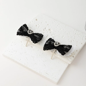 Détail de pinces à cheveux gothiques en dentelle noire avec ailes et croix argentées