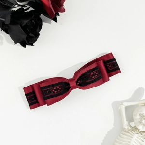 Detailed view of dark gothic red satin bow clip with intricate black lace layers