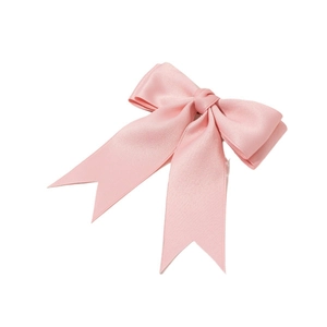 Detail of a pink satin ribbon bow hair clip with elegant fishtail ends on white background