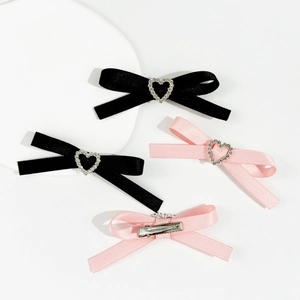 Barrettes à cheveux nœud de ballet rose et noir avec strass cœur sur plateau de vente