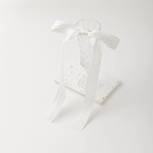 Détail d'un nœud en dentelle blanche sur verre en relief au style esthétique épuré