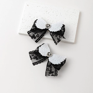 Détail de barrettes gothiques à ailes blanches avec dentelle noire et strass en cœur