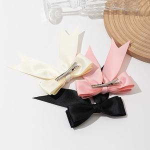 Three elegant satin bow hair clips in cream, pink, and black colors for women