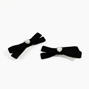 Detail of black velvet bow hair clips with sparkling heart-shaped rhinestone centers