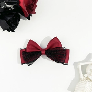 Dettaglio del fiocco goth in pizzo con raso rosso e accenti di rose scure eleganti