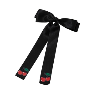Elegant black satin hair bow with long tails and red cherry prints for a sweet feminine look