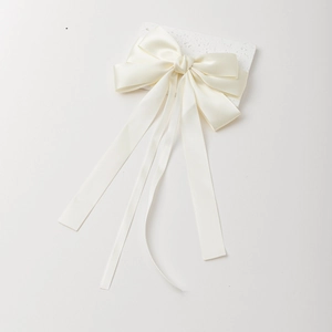Eleganter elfenbeinfarbener Satin-Haarclip mit Schleife und Bändern auf Steindisplay