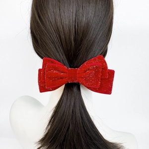 Elegant red velvet bow hair clip with silver glitter on deep brown ponytail hairstyle