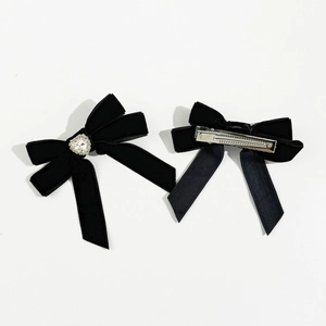 Detail view of black velvet bow hair clips with heart rhinestone and silver metal duckbill clip