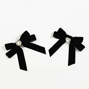 Detail view of black velvet bow hair clips with heart-shaped crystal rhinestones