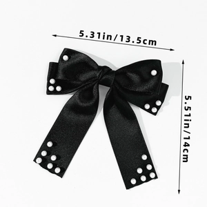 Vue détaillée du nœud papillon en satin noir avec perles et rubans longs pour cheveux