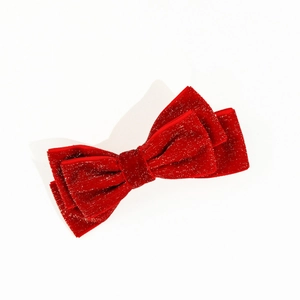 Detail of red velvet Christmas bow hair clip with silver glitter on white background