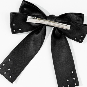 Vue détaillée arrière d'un nœud papillon en satin noir avec rivets et pince en métal