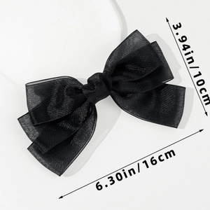 Detail view of a large black mesh bow hair clip featuring lightweight organza fabric