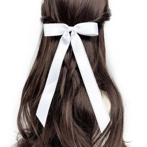 Vue arrière d'un mannequin portant un nœud papillon blanc avec dentelle sur cheveux bruns