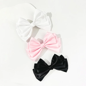 Three-piece set of large satin bow hair clips in white, pink, and black colors