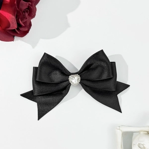 Elegante fermaglio per capelli in raso nero con cuore di strass su sfondo chiaro