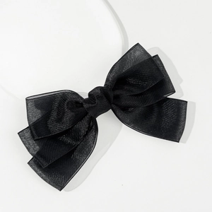 Detail showing the layered texture and sheer fabric of the black tulle bow hair clip