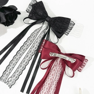 Dettaglio del bordo in pizzo e trama in raso della clip per capelli stile gotico con fiocco