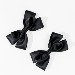 Detailansicht von zwei eleganten schwarzen Satin-Schleifen Haarspangen mit Seidentextur