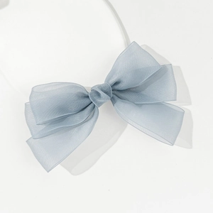 Detailed macro view of the semi-transparent blue organza bow and slim white headband