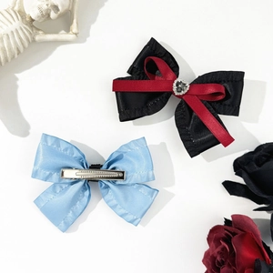 Detail of gothic bow hair clips featuring rhinestones and metal alligator clip backing