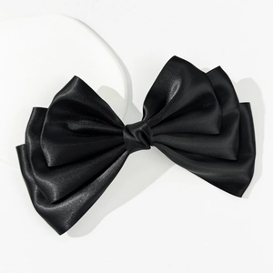 Detailed view of large black satin bow hair clip with layered 3D elegant design
