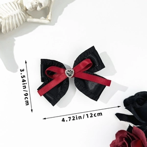Close-up of gothic bow hair clip with black heart gemstone and red silk accents