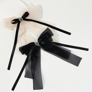 Detail view of large organza hair bows with rhinestone heart and elegant ribbons