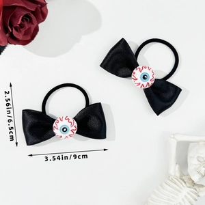Detail view of gothic eyeball bow hair ties with dimensions 9cm by 6.5cm on white backdrop