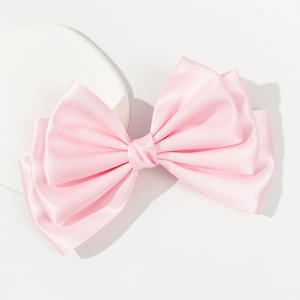 Elegant oversized pink satin bow hair clip with multi-layered silk design on white base