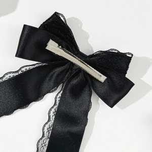 Detail of the silver metal duckbill clip on the back of a black lace bow hair clip