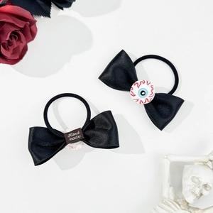 Detail of gothic Halloween bow hair ties with eyeball charms and handmade labels