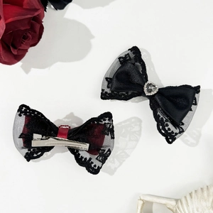 Close-up of gothic lace bow hair clips with heart crystal and silver duckbill clips