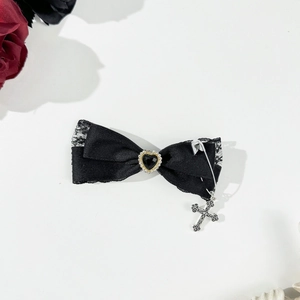 Macro detail of Gothic black lace bow hair clip with heart gem and cross metal pendant