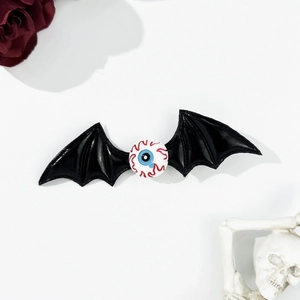 Macro shot of Halloween bat wing hair clip with realistic eyeball and gothic rose decor