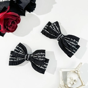 Gothic black ribbon hair clips with white script text and aesthetic rose background