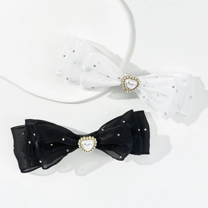 Detailed view of layered bow hair clips with rhinestones and heart-shaped pearls
