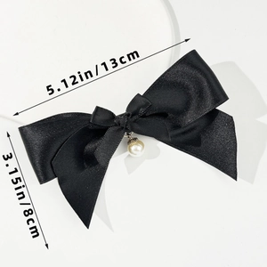 Detail view of a 13x8cm black satin bow hair clip featuring a faux pearl center ornament