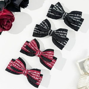 Gothic style bow hair clips set with white script lettering and lace trim in red and black