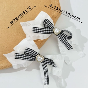 Detail von Lolita-Haarspangen mit schwarz-weißem Karo, Herzperle und Rüschenbesatz