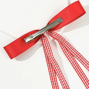 Detail view of the silver metal alligator clip on the red plaid ribbon bow hairclip