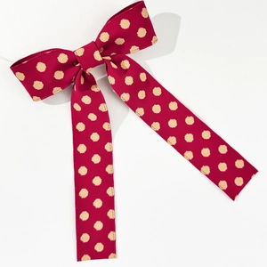 Vintage red polka dot ribbon bow hair clip with long streamers on white background