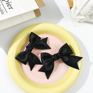 Sweet ballet style black satin double bow hair clips for women in aesthetic setting