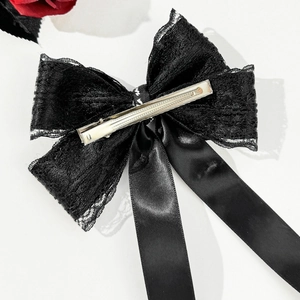 Close-up of black lace bow hair clip with silver spring metal fastener on the back