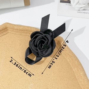 Détail d'une pince à cheveux camélia en satin noir faite main avec des rubans élégants