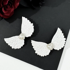 Gothic angel wing hair clips with rhinestone heart detail on black background